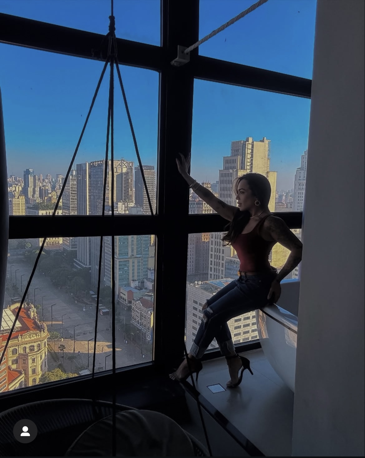 Mulher apreciando a vista da janela do Sky Loft