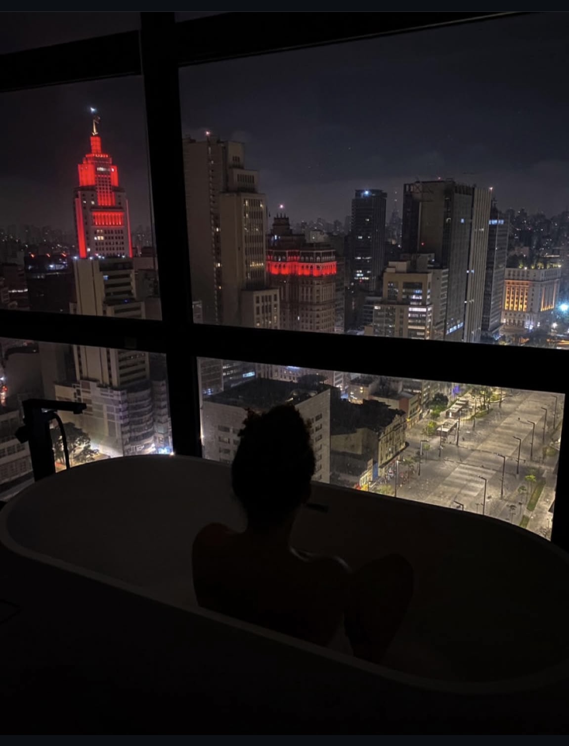 Banho relaxante com vista noturna de São Paulo